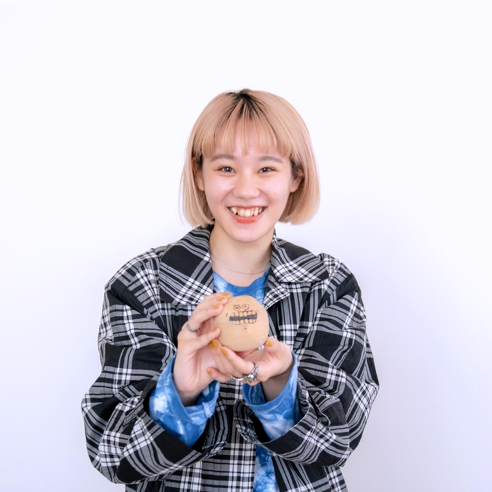 suzukiyuがジャガイモのキーホルダーを大事そうに持って笑っている写真
