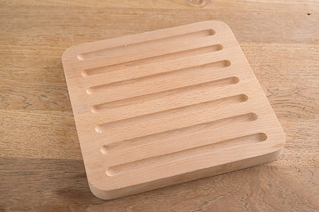 パン専用のまな板。表面の溝はパンくずを受けるだけでなく、均等に切りたいときの目安にもなる