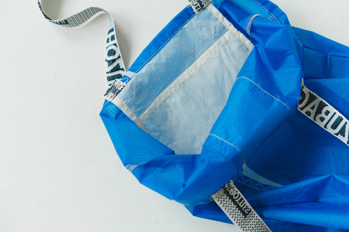 裁断後は、リサイクル原料でつくられたテープハンドルとブランドの象徴であるマテリアルタグを取り付け、ひとつずつ縫いあげていきます。