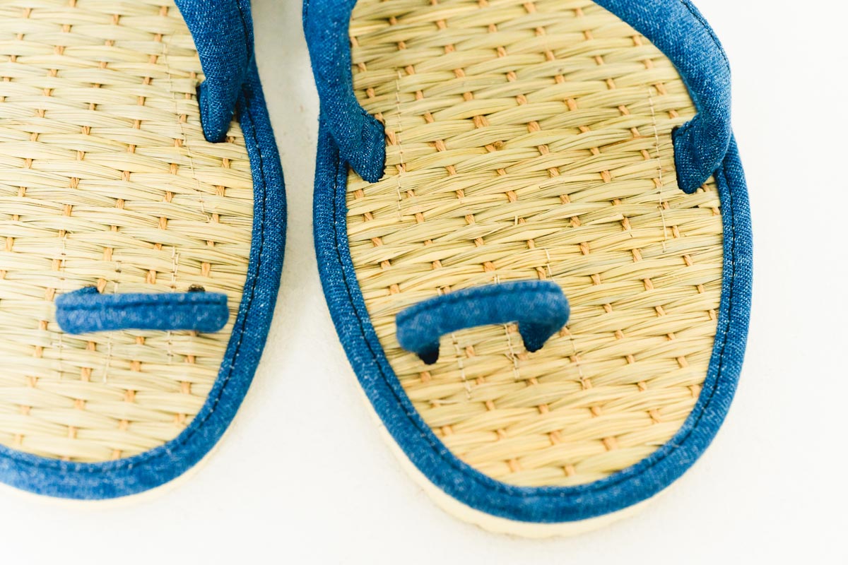 青木本店は1902年（明治35年）の創業以来、120年以上に渡り青表※問屋として歩み続けている会社です。このままでは七島藺の歴史が途絶えてしまう、この伝統をなんとかして守りたいという強い想いから、七島藺を使用した履き物づくりを始めました。