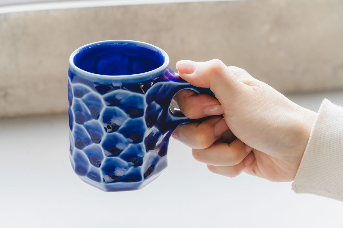 持ち手の部分には指を入れる穴が空いていますが、磁器は飲み物を入れると熱くなるため、指が熱くないように穴の大きさを考えたそう。