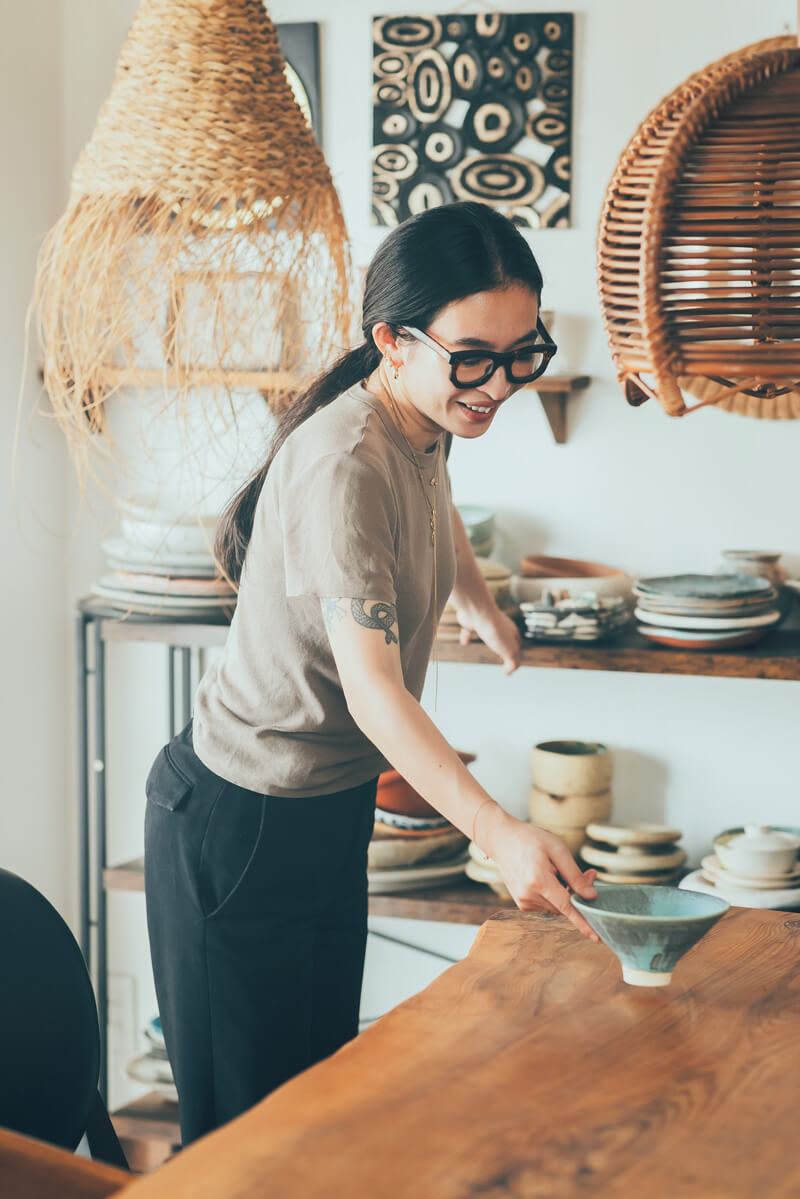 山野邉さんらしさがあふれる居心地のいいお部屋で。手に持っているのは自作の器